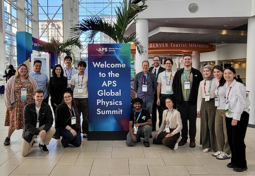 Photograph of SJSU physics students and faculty at standing in front of the APS Global Physics Summit welcome sign.