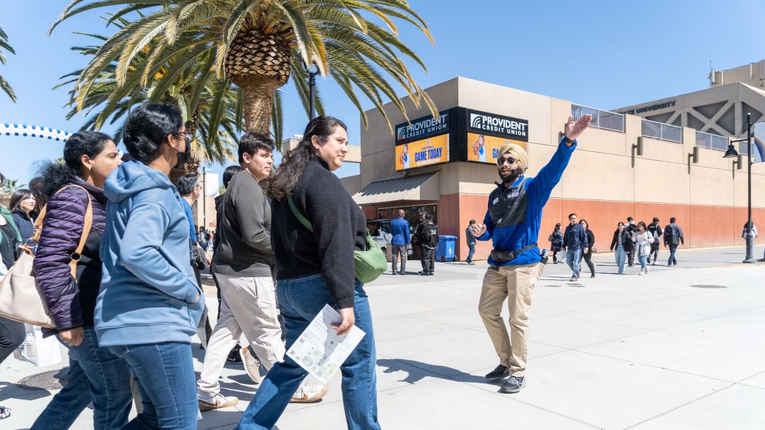 Student leads a campus tour on a sunny day