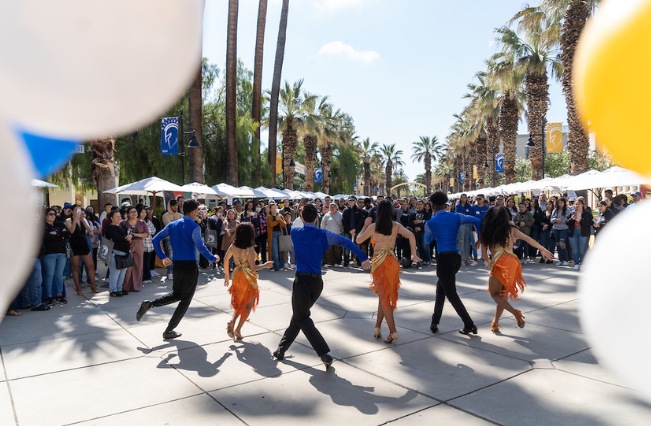 Dance performance of students in front of a crowd of people during Homecoming.
